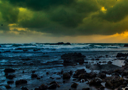 Stormy seascape with rocks on the foreground and stormy sky
