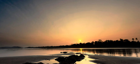 Sunset on the beach in the tropics. Panorama.