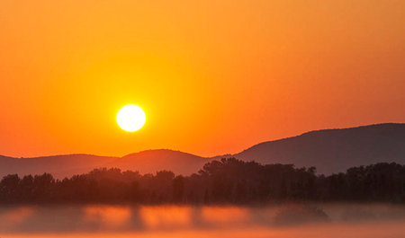 Sunrise over the lake in the foggy morning. Landscape.の写真素材