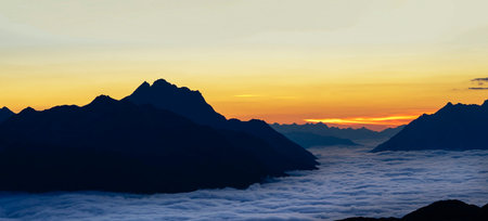 Sunrise over the clouds at the top of a mountain in Switzerlandの写真素材