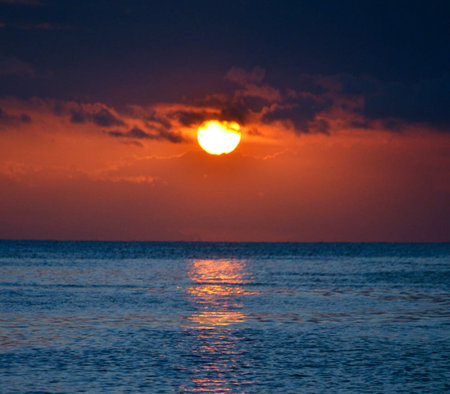 Beautiful sunset over the sea. The sun is reflected in the water.の写真素材