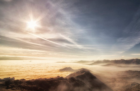 Beautiful sunrise above the clouds in the mountains. Nature background.