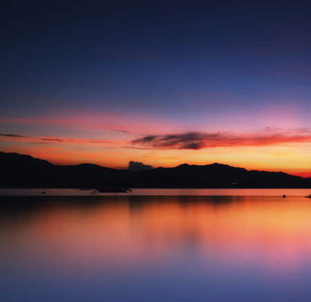 Beautiful sunset on the lake with mountains in the background, Thailand.の写真素材