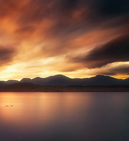 Beautiful sunset over a lake with mountains in the background, Scotlandの写真素材