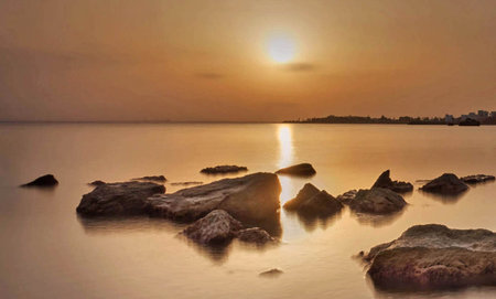 Sunset over the sea with stones in the foreground, Thailand.の写真素材
