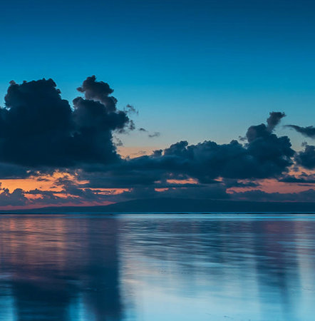 beautiful sunset on the sea with clouds reflected in the water.の写真素材