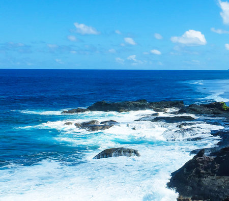 Beautiful seascape with ocean waves on the rocks and blue skyの写真素材