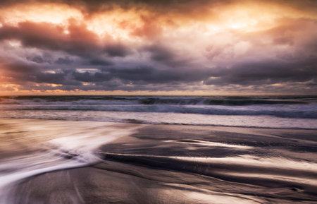 Beautiful seascape with stormy sky and waves at sunsetの写真素材