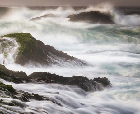 Beautiful seascape with a long exposure of ocean waves crashing on rocksの写真素材