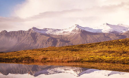 Icelandic landscape with mountain lake and snowcapped peaks.の写真素材