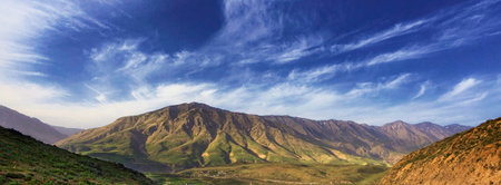 Panoramic view of mountains and blue sky with white clouds.