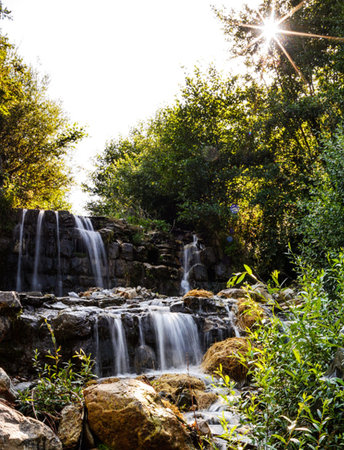 Waterfall in the forest with sunbeams and lens flare.の写真素材