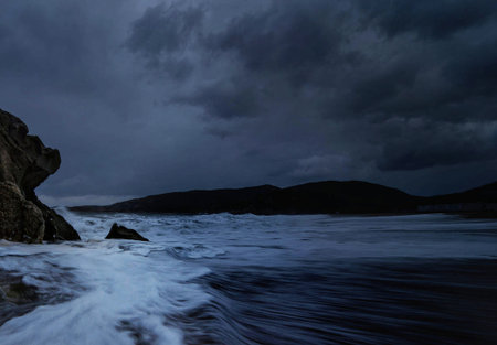 Long exposure of stormy seascape with stormy sky and rocks