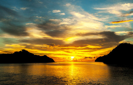 Beautiful sunset over the sea at stony sea coast of peninsula Santubong. Borneo.