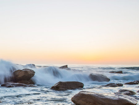 Beautiful seascape with rocks and water splashes at sunset