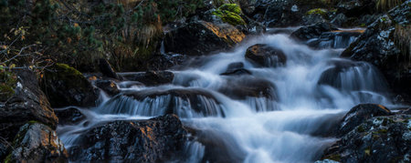A long exposure of a waterfall flowing over rocks in the Scottish Highlandsの写真素材