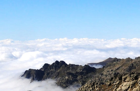 Mountain landscape with clouds and blue sky. View from the top of the mountain.