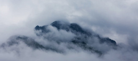 Panoramic view of a mountain covered with clouds in the morningの写真素材
