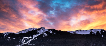 Panoramic view of the snowy mountains at sunset in winter.の写真素材