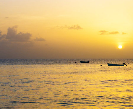 Beautiful sunset over the sea with boat silhouette in the foreground.の写真素材