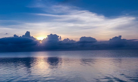 Beautiful sunset on the sea. Seascape with clouds reflected in waterの写真素材