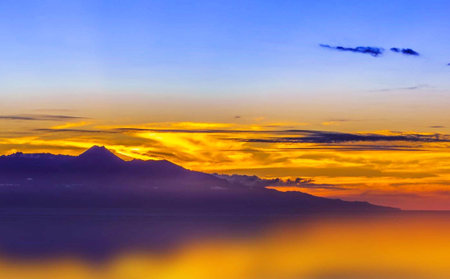 Sunset over the sea and mountains in the background of the skyの写真素材