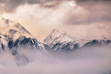 Beautiful winter landscape with snow-capped mountains in the clouds