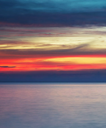 Beautiful sunset on the sea. Colorful sky with clouds.の写真素材