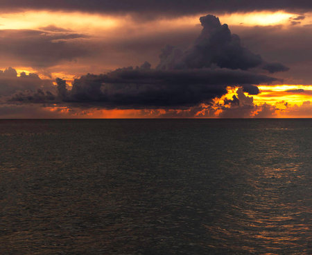 Dramatic sunset over the sea with clouds in the sky.の写真素材