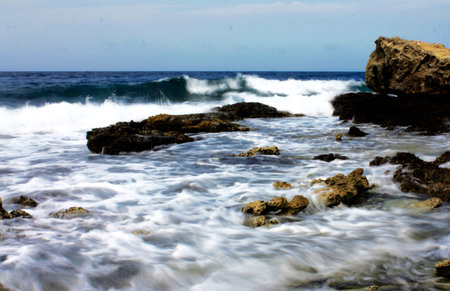 waves crashing against the rocks on the beach, photo as a background, digital imageの写真素材