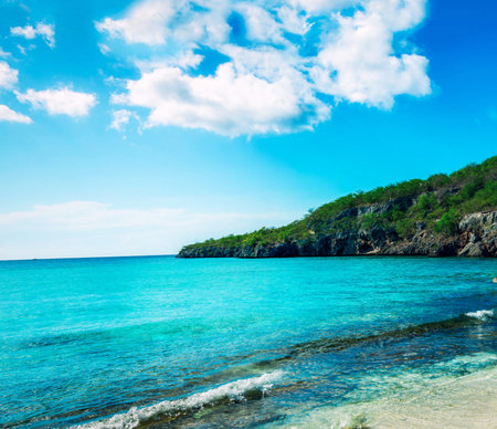 beautiful beach and tropical sea under the blue sky with white cloudsの写真素材