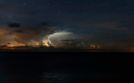 Beautiful night sky with stars and clouds over the sea. View from the sea.の写真素材