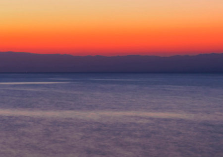 Sunset over the sea with a view of the mountains in the background
