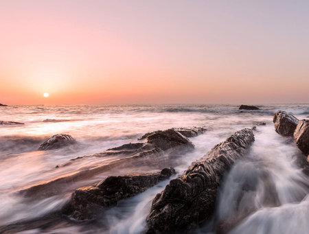 Beautiful seascape with sea wave and rock at sunset timeの写真素材