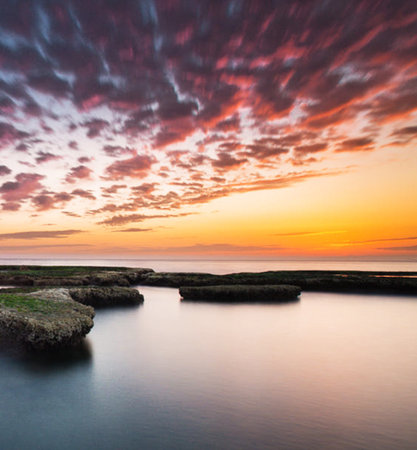 Beautiful sunset over the sea. Colorful sky with clouds.の写真素材
