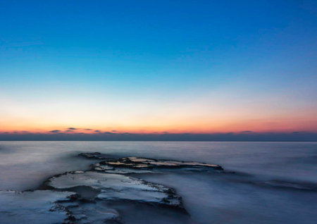 Beautiful sunset over the sea. The sun sets over the horizon.の写真素材