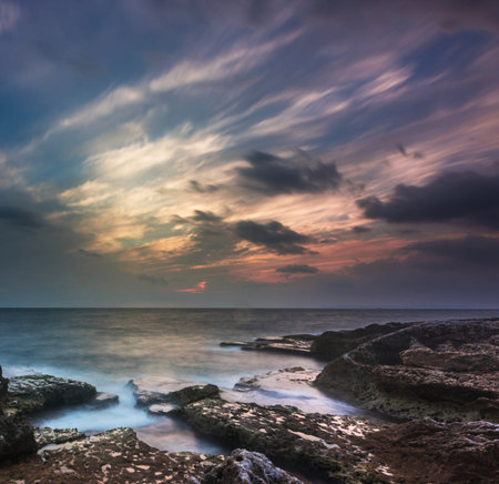 Beautiful sunset over the sea. Dramatic sky. Long exposureの写真素材