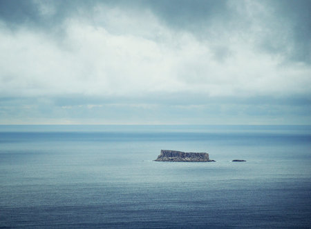 Island in the middle of the sea on a cloudy day.の写真素材