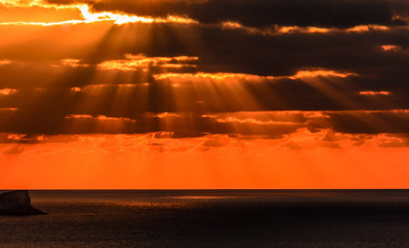 Sunset over the sea with sunbeams and rays of light