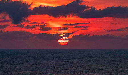 Sunset over the sea in the tropics. The sky is red and orange.の写真素材