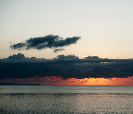 Beautiful sunset over the sea. Colorful sky with dark cloudsの写真素材