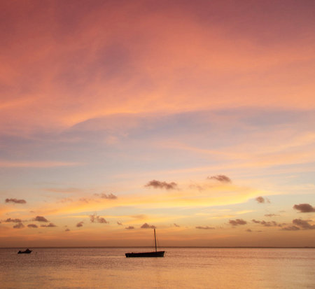 Beautiful sunset over the sea. Colorful sky with clouds and boat.の写真素材