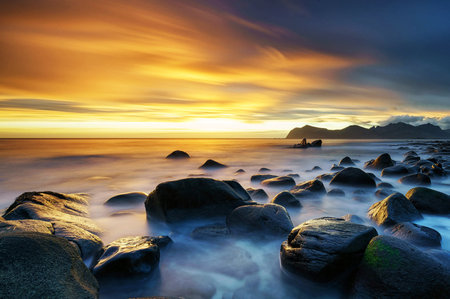 Long exposure of rocks on the beach at sunset. Beautiful seascape.
