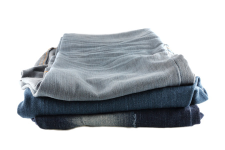 Many jeans stacked isolated  on a white backgroundの写真素材