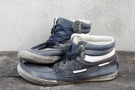 Used old sneakers on the wooden floor.の写真素材
