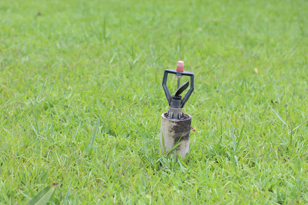 Automatic water sprinkler on green grass.の写真素材