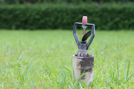 Automatic water sprinkler on green grass.の写真素材