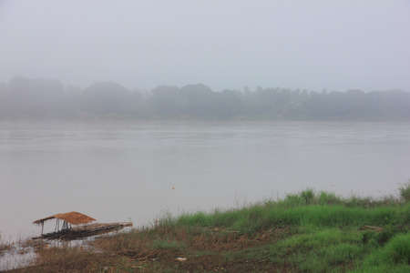 Bamboo hut on riverside covered by mist.の写真素材