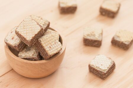 Wafers with chocolate in cup on wooden background.の写真素材
