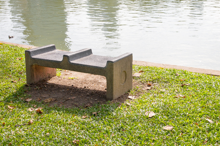 Stone bench beside lake in the park.の写真素材